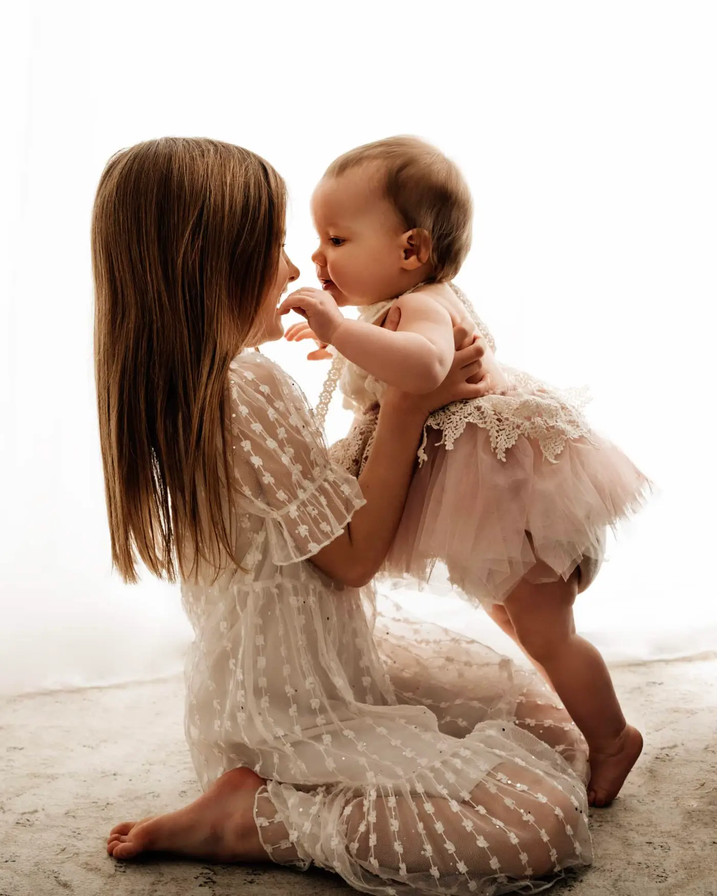 two sisters looking at eachother on a bradford baby photographer photoshoot