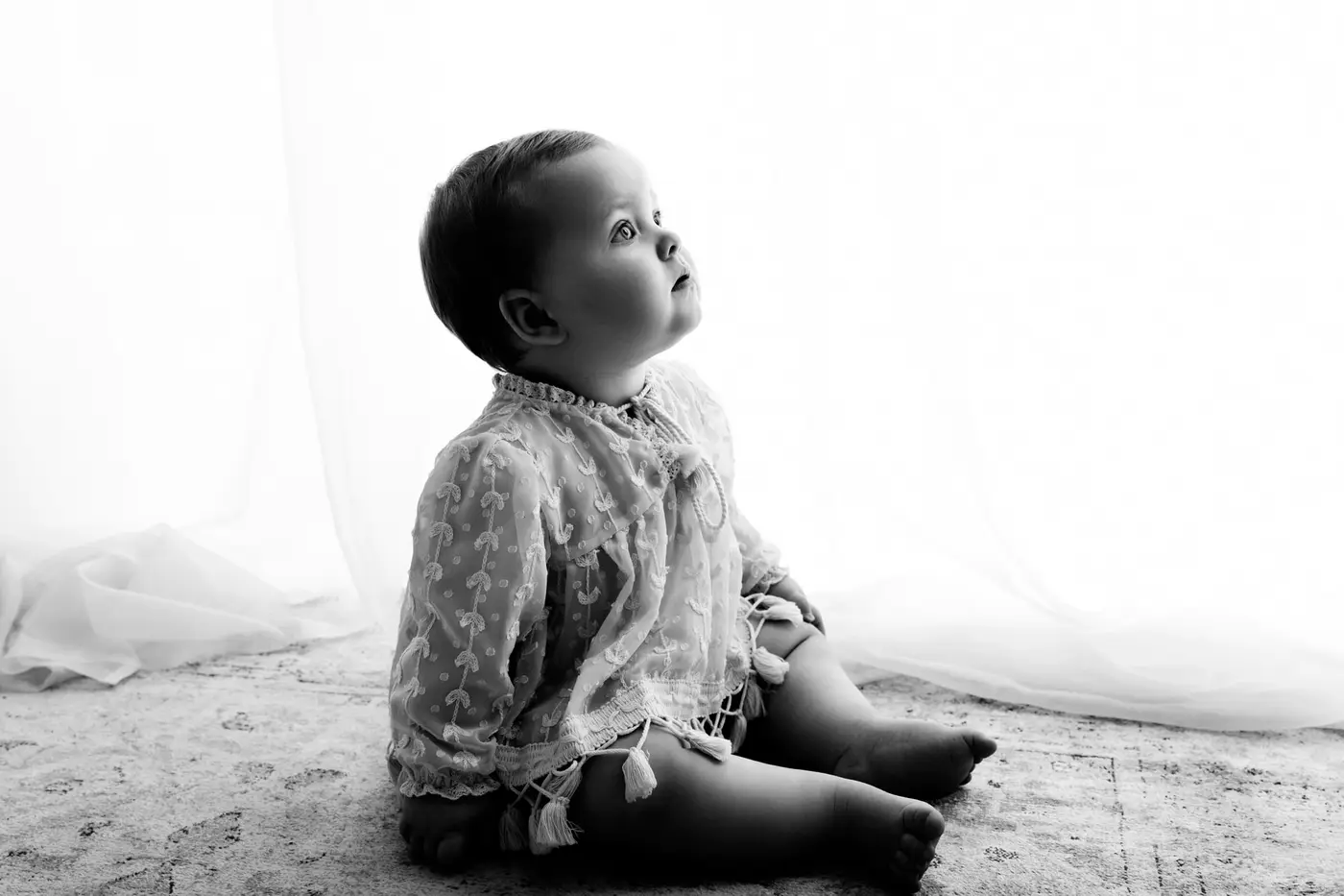 black and white image of a baby looking up during a bradford baby photographer photoshoot