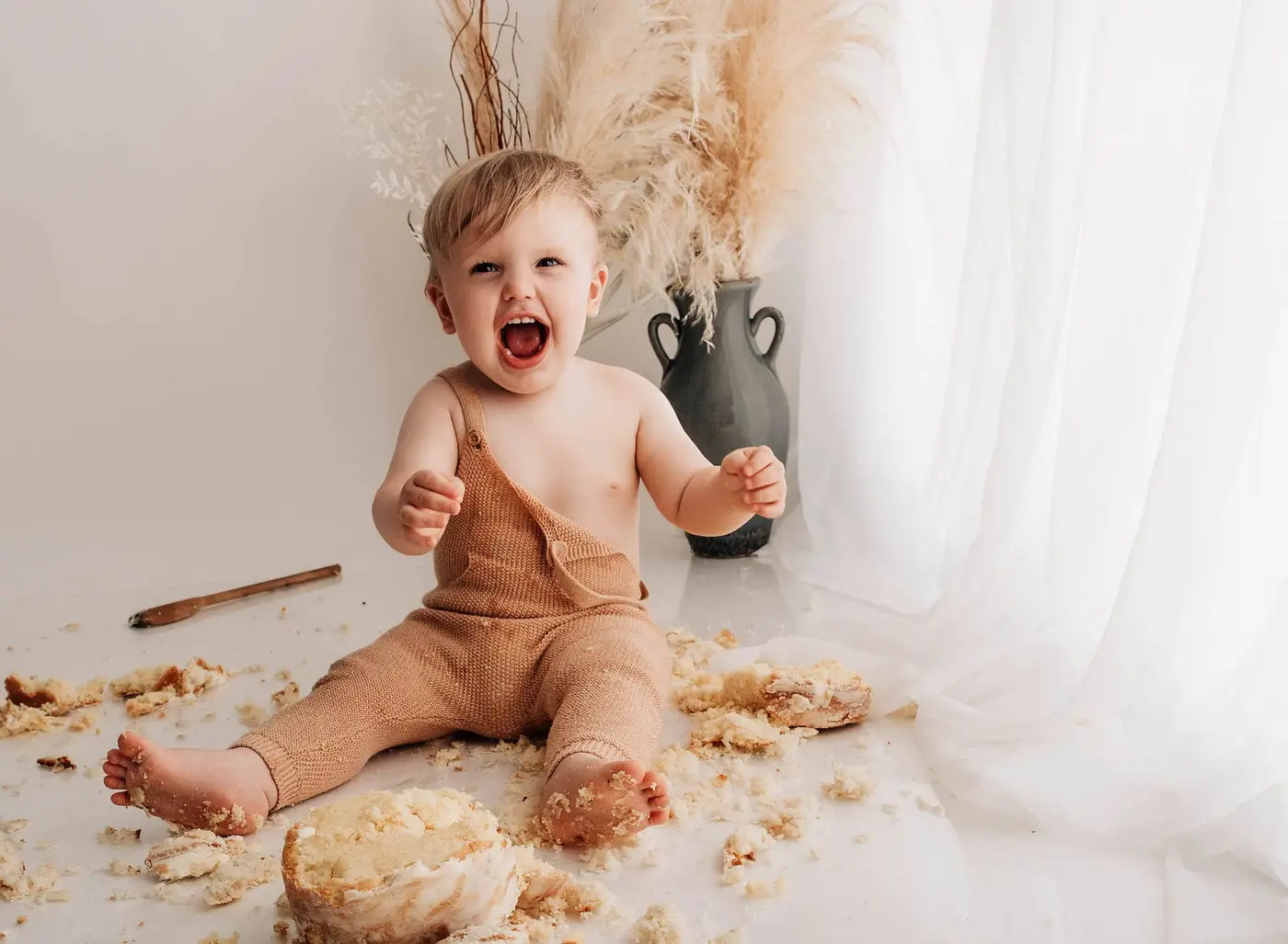 happy baby with cake during a bradford cake smash photographer shoot