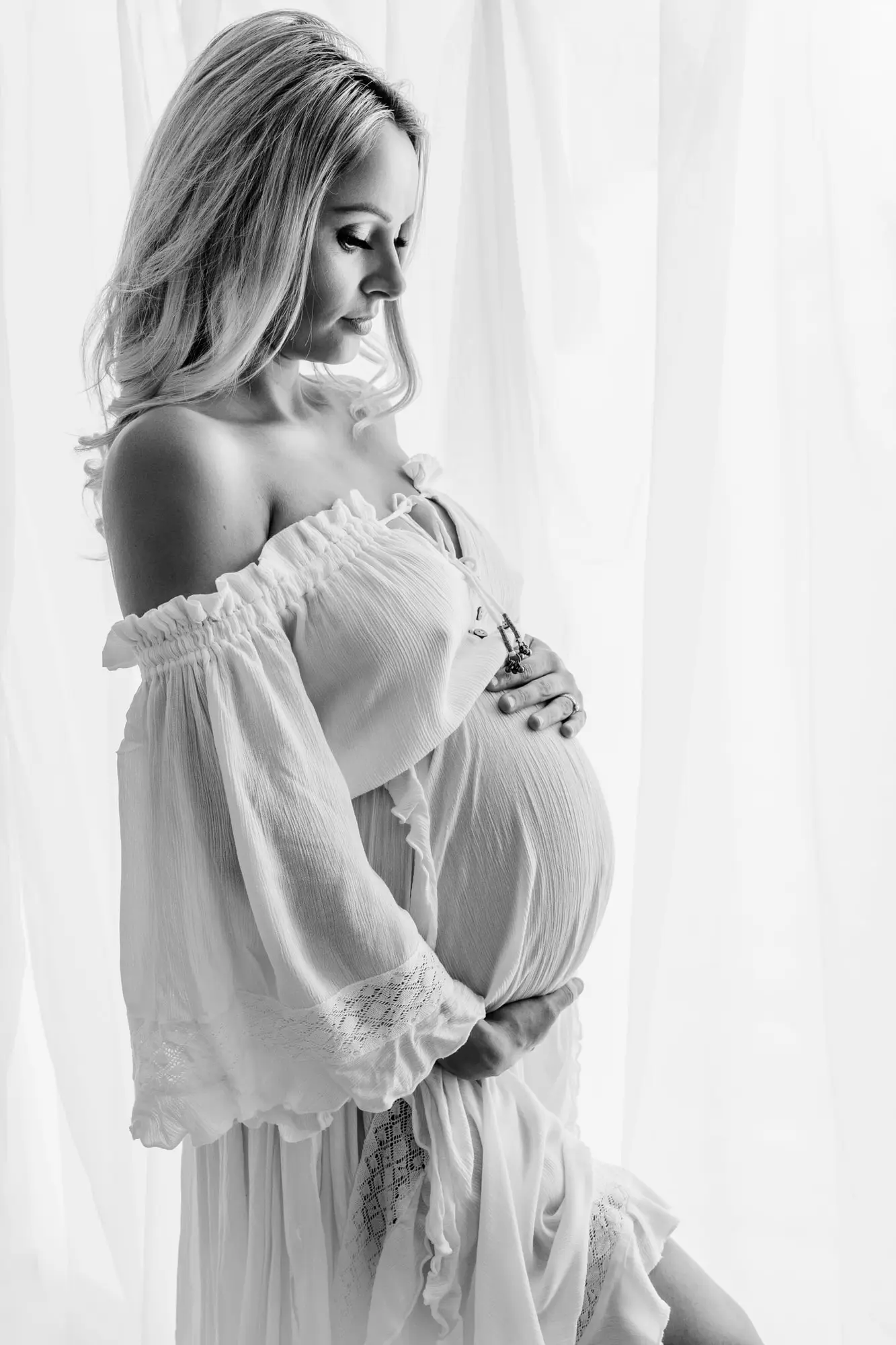 black and white im age of a lady holding her bump during a cleckheaton maternity photographer photoshoot